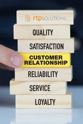 Image of jenga blocks representing how RTP Solutions wrok with blocks for quality at the top, satisfaction, customer relationship which is a yellow block that someone is pulling, reliability, service and loyalty following after.